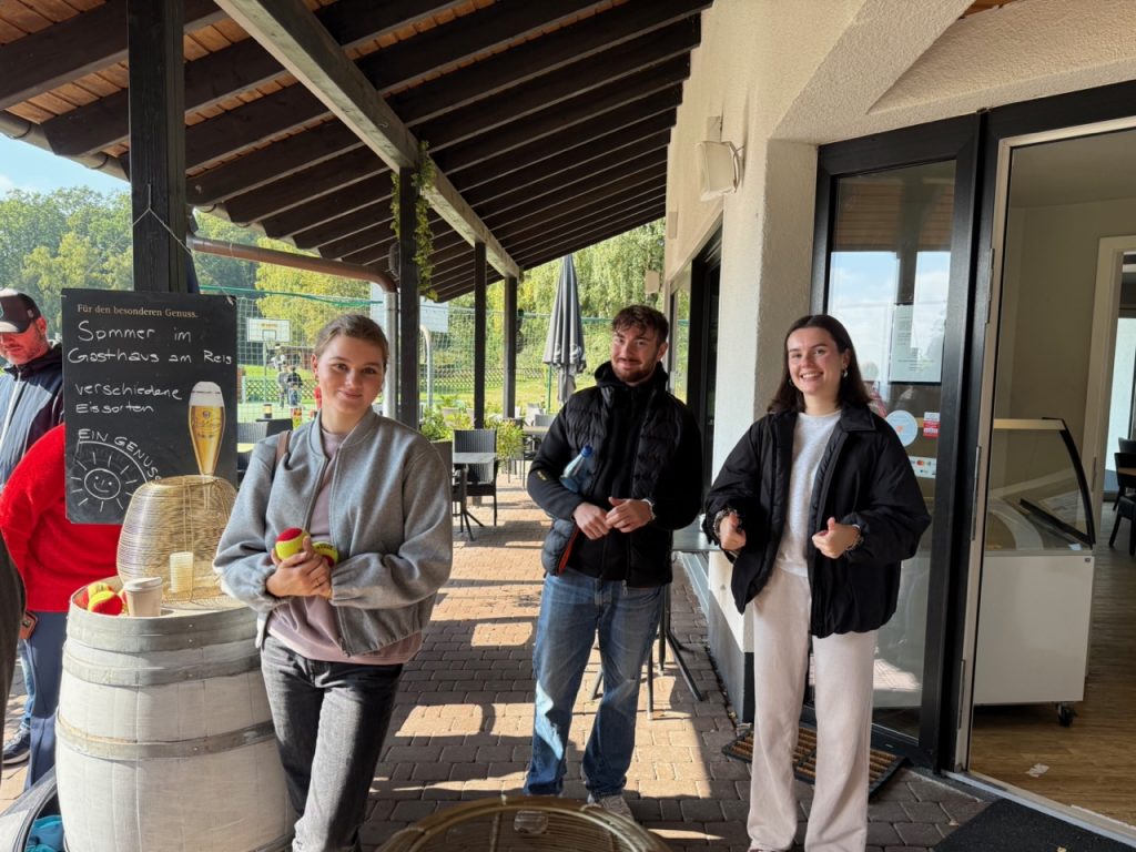 Drei Personen vor Gasthaus