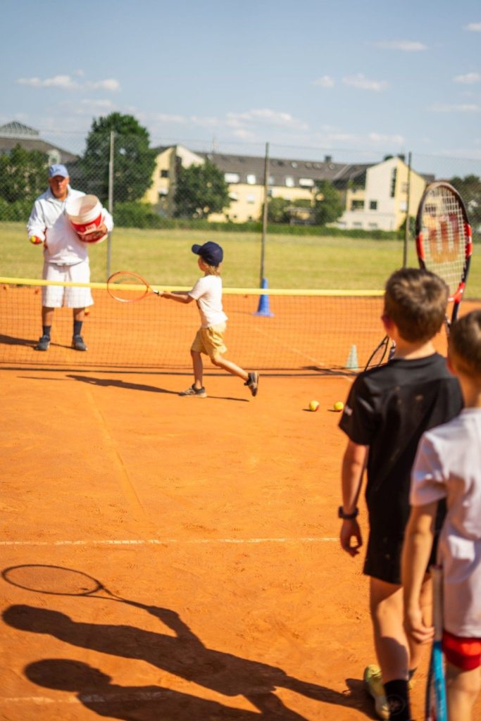 Kind beim Tennisunterricht