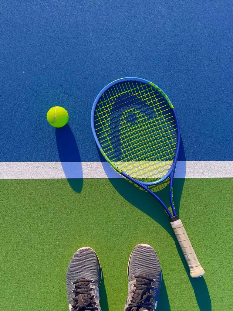 Tennisschläger und Ball auf Platz