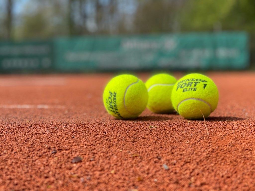 Tennisbälle auf rotem Platz